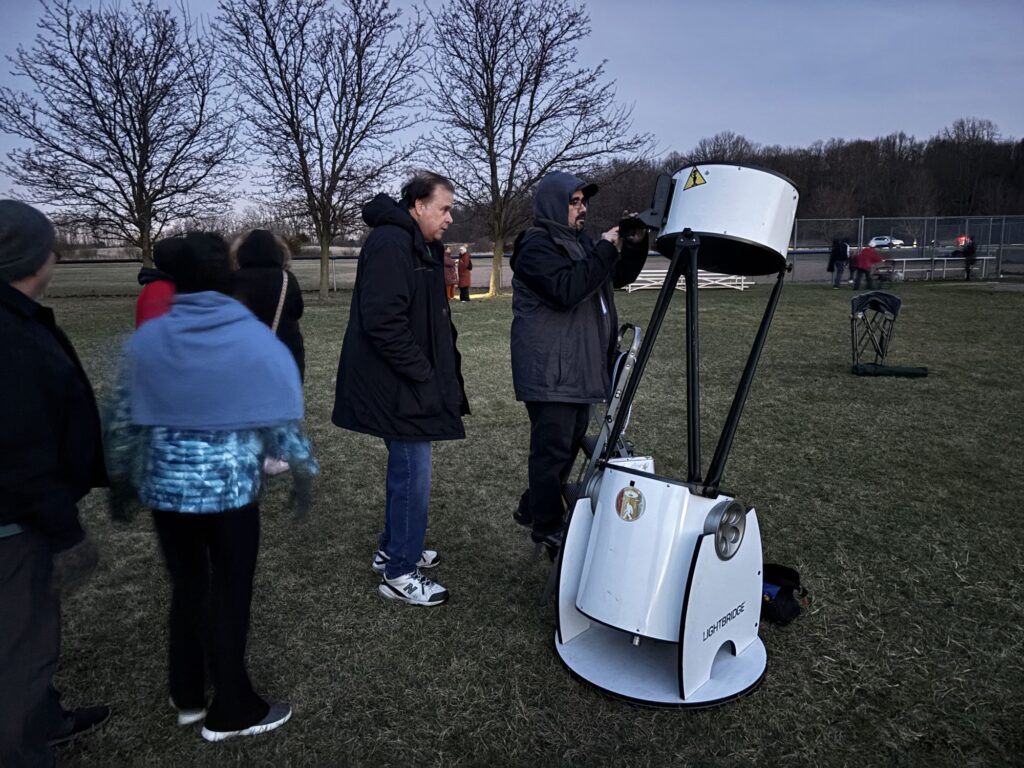 Maybury Star-Gazing event, Samer adjusting the lens in his telescope